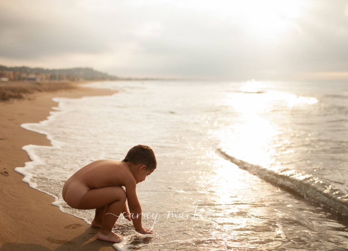 Niño en la playa al amanecer. 
